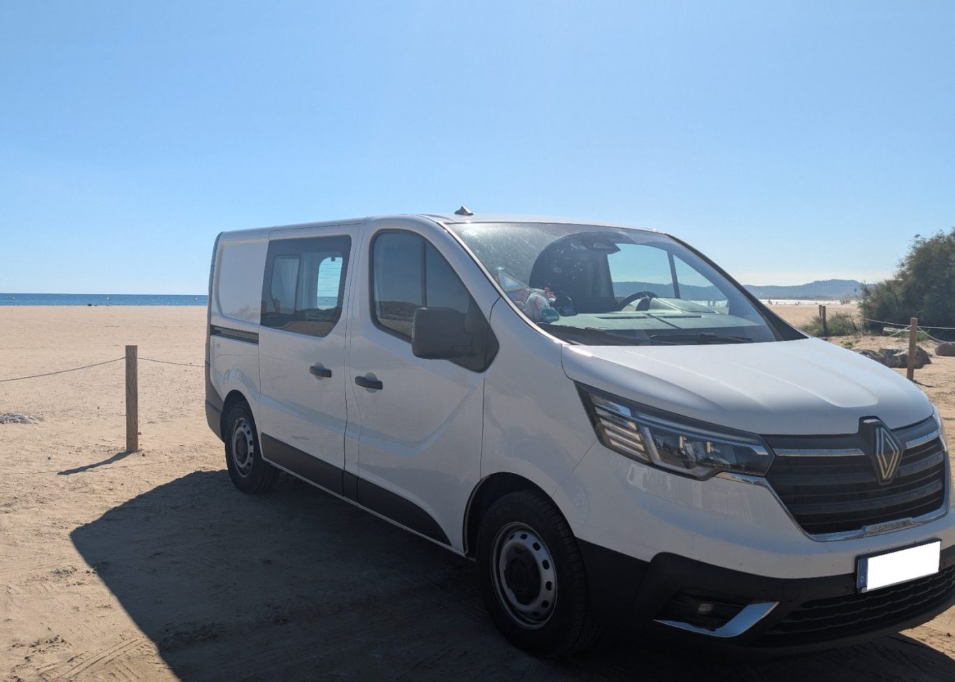 Gemeinsame Ziele: Mit dem selbstausgebauten Camper an der Costa Brava © Feb. 2026 Tanja Schöffmann Weißer Renault Trafic, selbstausgebauter Camper am Strand an der Costa Brava, ein Symbol für Paarziele und Freiheit