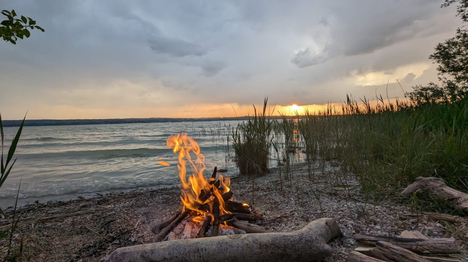 Gemeinsam am Lagerfeuer - Geborgenheit & Harmonie für mich© Feb. 2026 Tanja Schöffmann Lagerfeuer am Ufer eines ruhigen Sees bei Sonnenuntergang. Ein Symbol für Geborgenheit und Harmonie